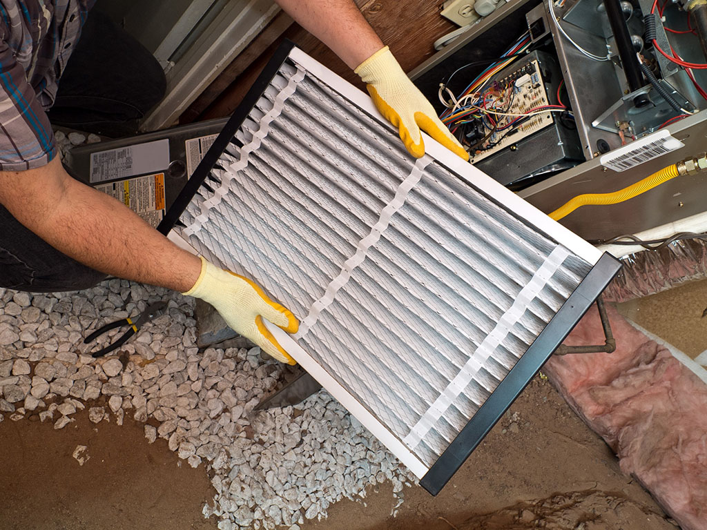 tech replacing filter as part of heating maintenance in houston, tx