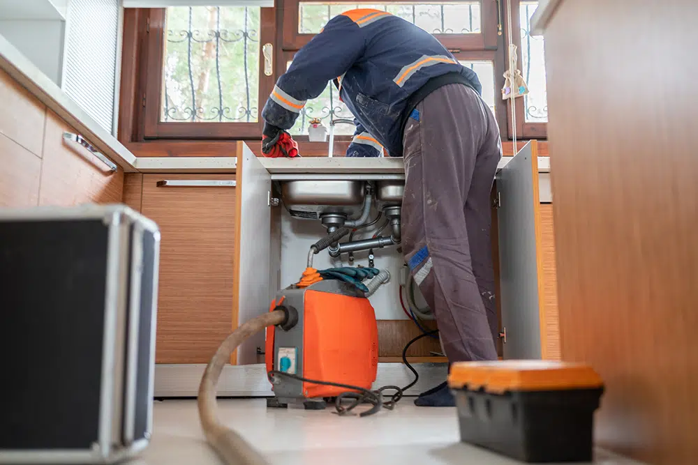 Technician working on garbage disposal in Houston, TX.