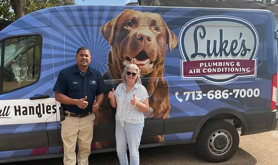 Greg from Luke's Plumbing & Air and a satisfied Houston customer giving thumbs up in front of the company van