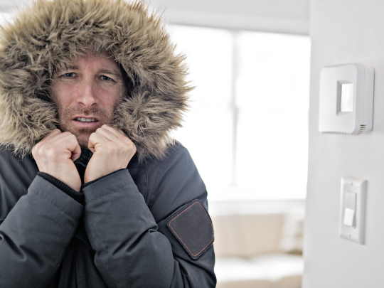 man wearing jacket and fur hood inside houston home because furnace needs to be serviced